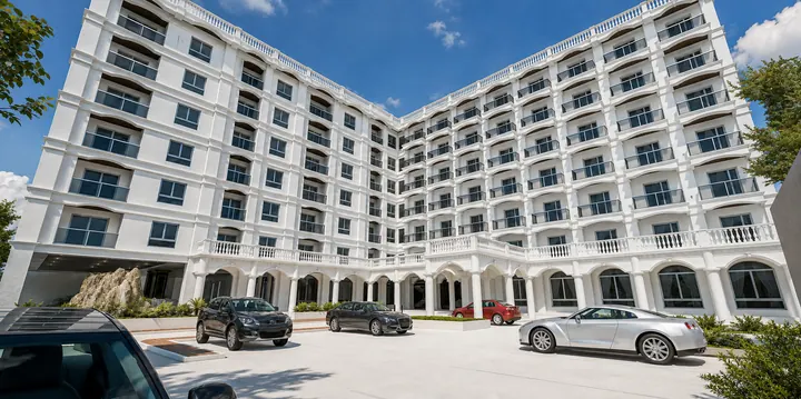 White condominium courtyard with balconies, arched colonnades and the arrival driveway