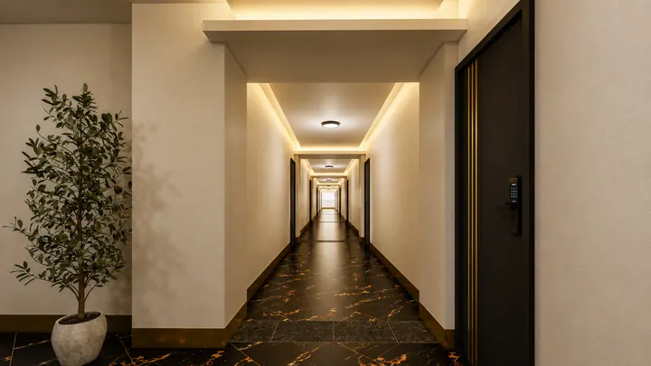 Residential corridor with warm cove lighting, dark doors and a black marble floor
