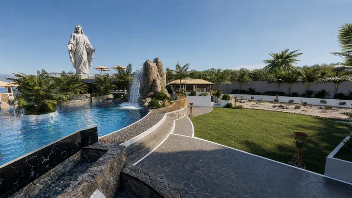 Rock waterfall flowing into the landscaped pool beside the lawn and statue terrace